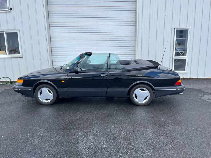 Side profile of the 1988 Saab 900 Turbo Convertible SIS Edition, highlighting its sleek black exterior and elegant convertible design, making it a standout piece on the auction block.