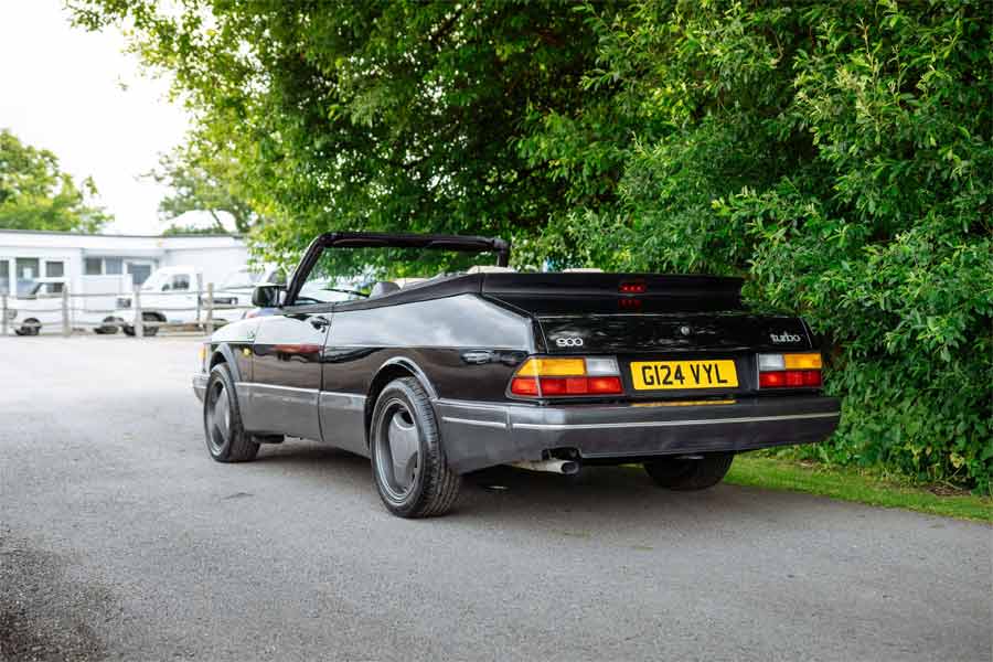 The rear view of the 1990 Saab 900 T16S FPT Convertible, highlighting its sleek black paintwork, factory ‘Aero’ kit, and distinctive Super Aero wheels.