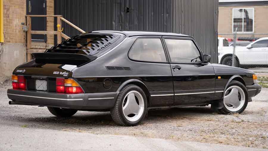 Capturing the sleek lines and distinctive silhouette, this image showcases the 1993 Saab 900 Turbo Commemorative Edition from the rear right angle, highlighting its elegant design and unique heritage.