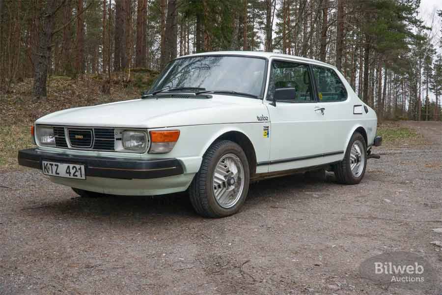 Front angle view of the 1980 Saab 99 Turbo in a natural setting, showcasing its sleek design and iconic turbo insignia.