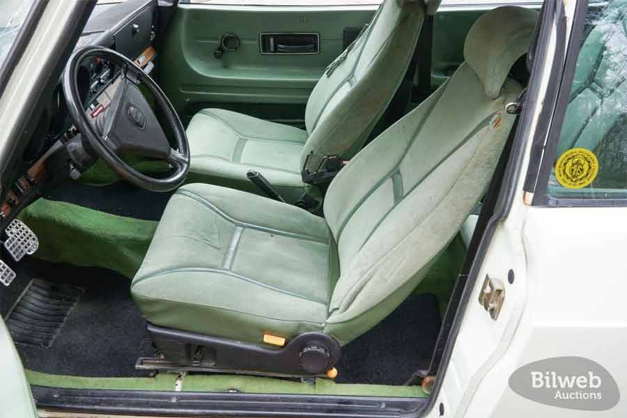 Interior view of the 1980 Saab 99 Turbo, featuring its original green upholstery and classic dashboard design.