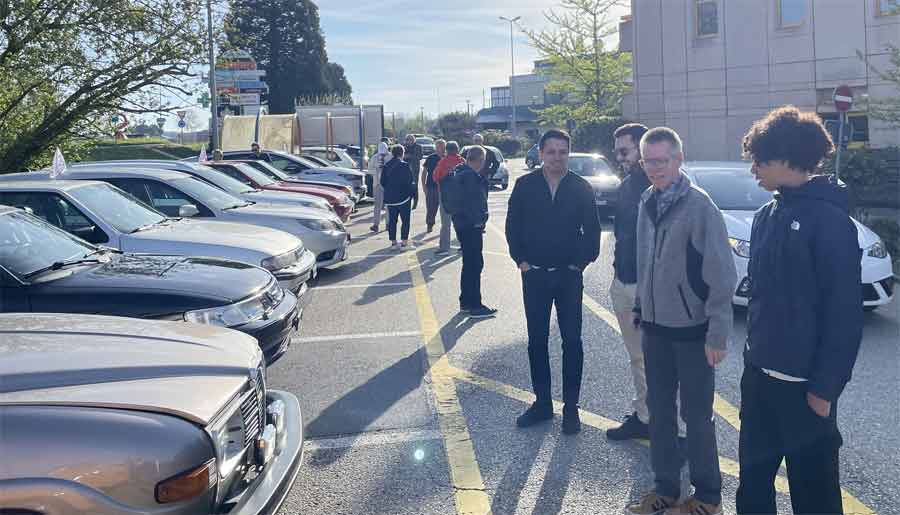 SAAB aficionados gather amidst a lineup of heritage vehicles, sharing stories and admiration for their beloved classics at the SAAB Club Romandie event.