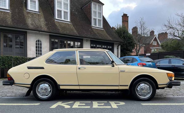 A classic 1981 Saab 900 GLS in pristine condition, showcased in a charming urban setting, illustrating the timeless elegance of Swedish automotive design.