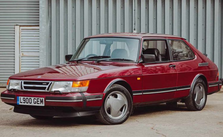 1993 Saab 900 Turbo Ruby Edition in pristine condition, showcasing its classic Ruby Red finish and distinctive three-spoke alloy wheels.