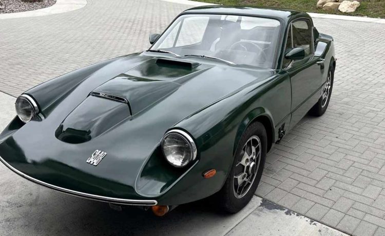 A meticulously restored 1969 Saab Sonett II V4 in a striking green, featuring classic 'soccer-ball' alloy wheels and a distinctive clamshell hood.