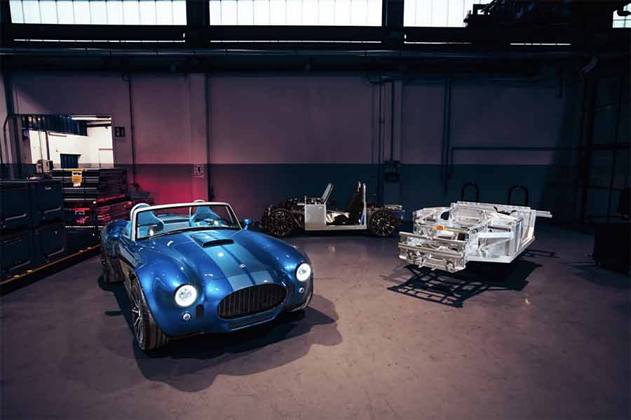 A glimpse at the AC Cobra GT Roadster alongside its aluminum chassis and partially assembled frame, illustrating the intricate craftsmanship that will soon take place in Trollhättan’s former Saab factory.