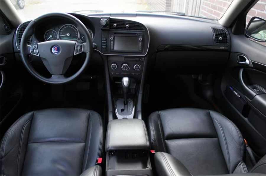 "Luxurious black leather interior of the Saab 9-3 Aero, enhanced with carbon-fiber inserts around the gearshift and door and glove compartment trim, melding elegance with sportiness.