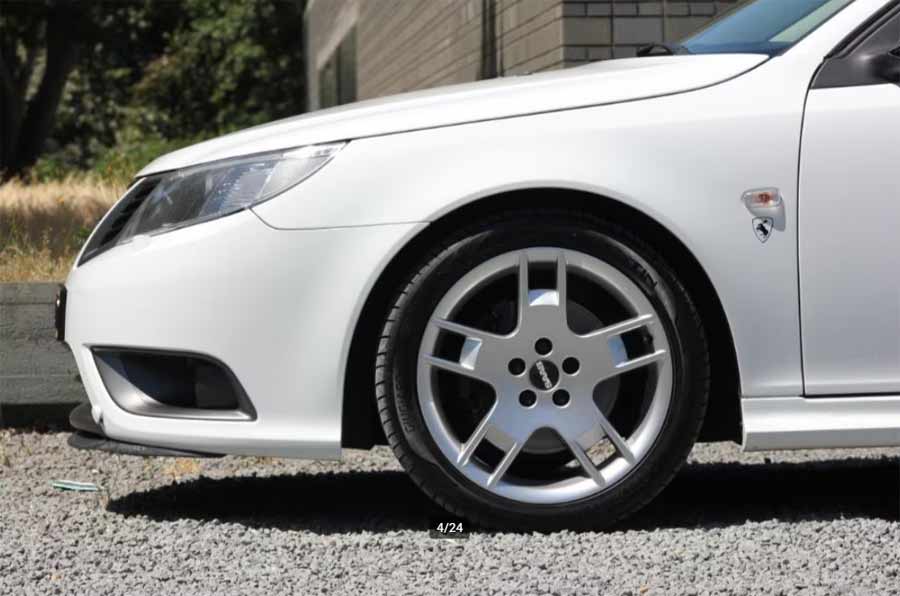 Close-up view of the rare ALU56 alloy wheels alongside the Turbo X-inspired front end of the Saab 9-3 Aero, blending performance with style.