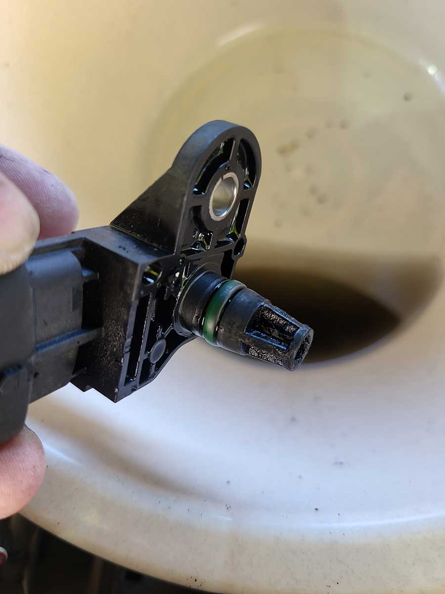 A close-up of the MAP sensor during the cleaning process. Proper cleaning with a MAP/MAF cleaner ensures that all dirt and carbon buildup are removed, allowing the sensor to provide accurate pressure readings essential for engine efficiency.