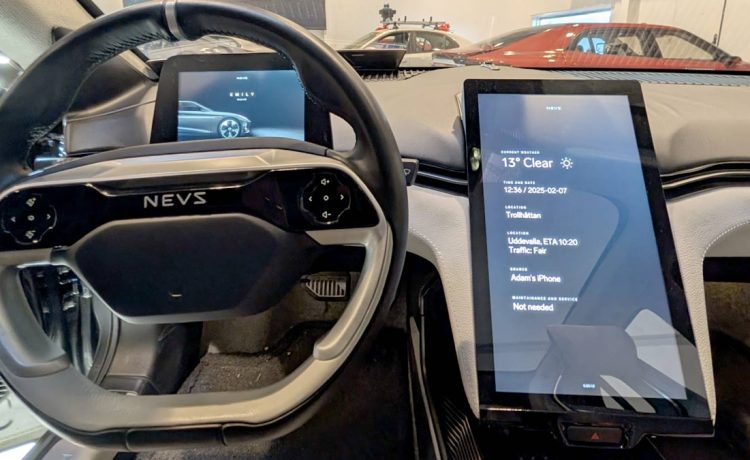 Inside the NEVS Emily GT: A futuristic cockpit featuring a driver display mounted on the steering column and a large central touchscreen, designed for an intuitive and immersive driving experience.