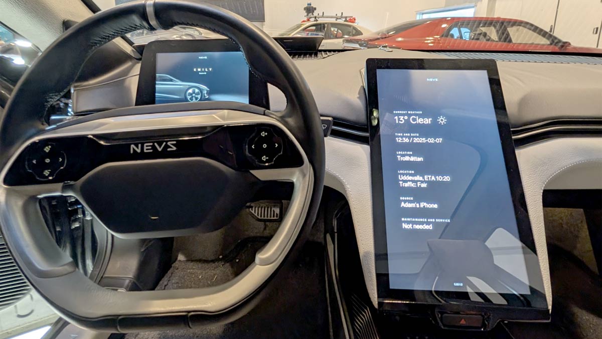 Inside the NEVS Emily GT: A futuristic cockpit featuring a driver display mounted on the steering column and a large central touchscreen, designed for an intuitive and immersive driving experience.