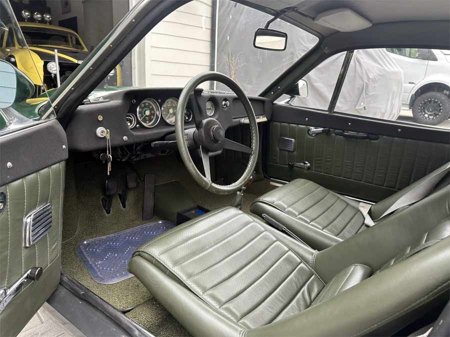 Interior view of the 1969 Saab Sonett II V4, featuring its beautifully preserved dark green upholstery and classic dashboard design.