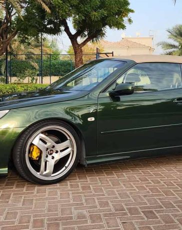 A beautifully customized green Saab 9-3 Convertible, meticulously upgraded by Dušan Marjanović in Dubai, showcasing unique design elements and Hirsch Performance alloy wheels.