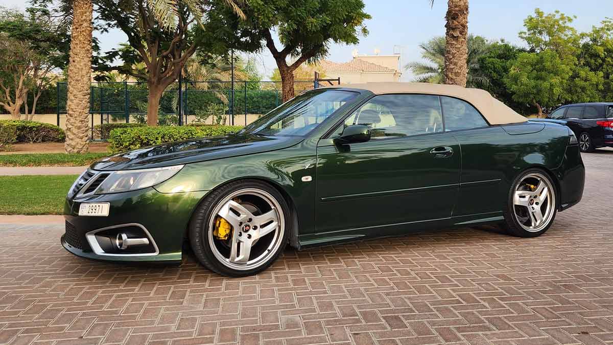 A beautifully customized green Saab 9-3 Convertible, meticulously upgraded by Dušan Marjanović in Dubai, showcasing unique design elements and Hirsch Performance alloy wheels.