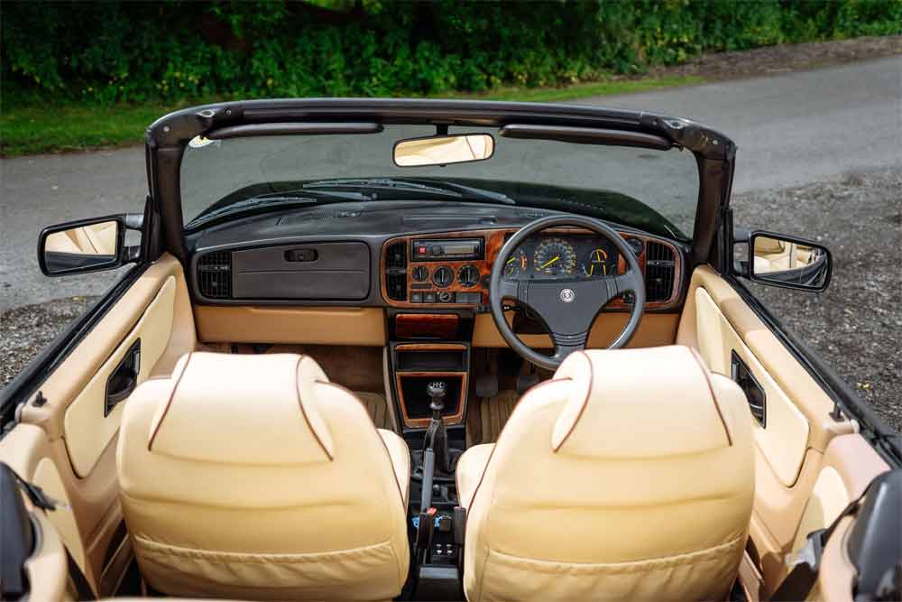 The elegant cream leather interior of the 1990 Saab 900 T16S FPT Convertible, featuring contrast piping and optional veneer trims on the dashboard and console.