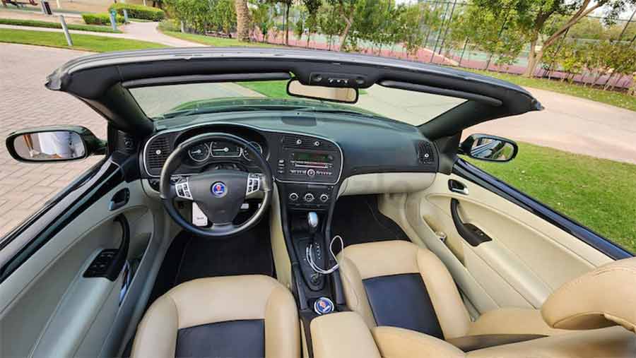 green paint is perfectly complemented by the beige leather interior, featuring newly refurbished seats. The beige top provides a practical solution for the sunny Dubai climate, while the interior's luxurious details, including the Turbo X steering wheel and leather door handles, add a touch of sophistication and comfort.