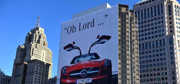 Under the shadow of Mercedes-Benz's grand display, a small Saab guerrilla stand makes a valiant effort to captivate the crowd, as indicated by the red arrow.