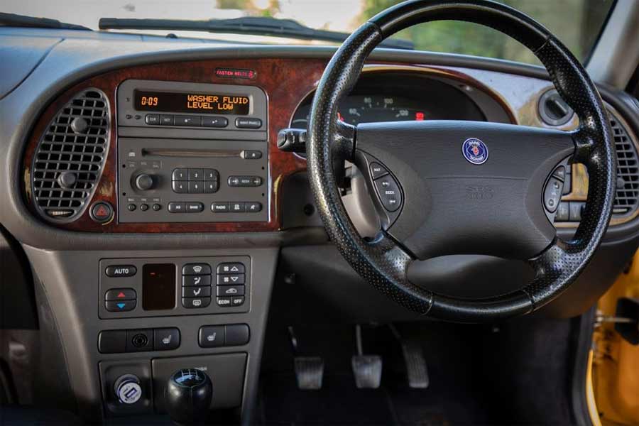 "Experience Luxury and Style in the Impeccable Black Leather Interior of 1999 Saab 9-3 Monte Carlo #9 - Perfectly Complemented by Carbon Fiber Dash Kit