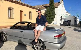 Nicolas Ruis proudly sits on his 2000 Saab 9-3 Aero Convertible, a car he has restored to its former glory and continues to enjoy on memorable road trips across Europe, embodying the passion and dedication of true Saab enthusiasts.