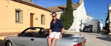 Nicolas Ruis proudly sits on his 2000 Saab 9-3 Aero Convertible, a car he has restored to its former glory and continues to enjoy on memorable road trips across Europe, embodying the passion and dedication of true Saab enthusiasts.