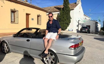 Nicolas Ruis proudly sits on his 2000 Saab 9-3 Aero Convertible, a car he has restored to its former glory and continues to enjoy on memorable road trips across Europe, embodying the passion and dedication of true Saab enthusiasts.