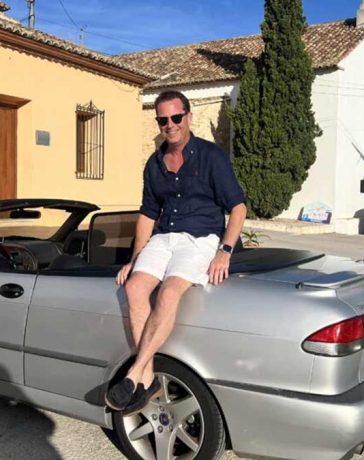 Nicolas Ruis proudly sits on his 2000 Saab 9-3 Aero Convertible, a car he has restored to its former glory and continues to enjoy on memorable road trips across Europe, embodying the passion and dedication of true Saab enthusiasts.