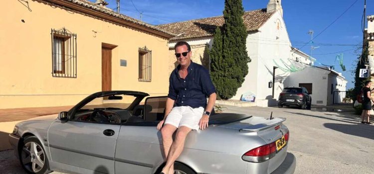 Nicolas Ruis proudly sits on his 2000 Saab 9-3 Aero Convertible, a car he has restored to its former glory and continues to enjoy on memorable road trips across Europe, embodying the passion and dedication of true Saab enthusiasts.