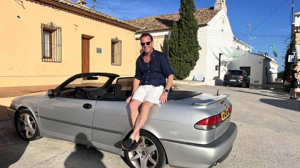 Nicolas Ruis proudly sits on his 2000 Saab 9-3 Aero Convertible, a car he has restored to its former glory and continues to enjoy on memorable road trips across Europe, embodying the passion and dedication of true Saab enthusiasts.