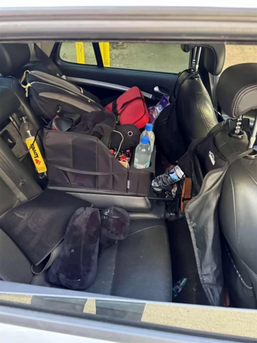  The rear seat of the Saab 9-5 Aero, transformed into a resting zone for off-shift team members, stocked with essentials for endurance and comfort during the Cannonball Run.