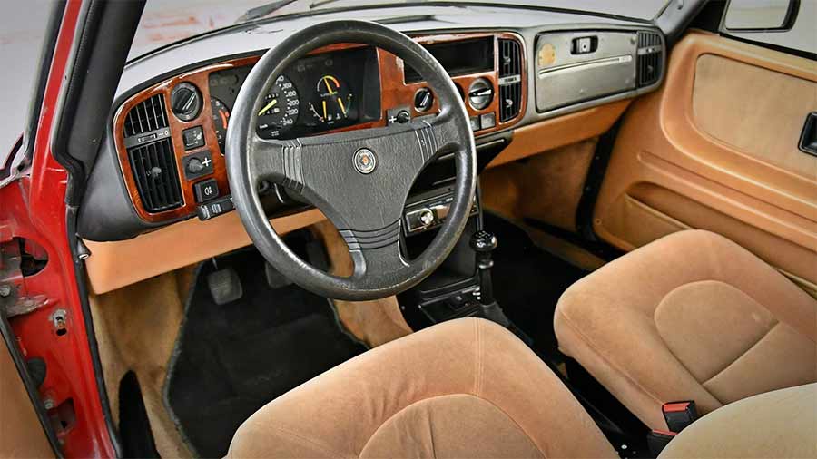 Interior of the Saab 900 Red Arrow, featuring the tan velour seats and Carlsson steering wheel, elements that define its reputation as the 'poor man's Carlsson' in this rare Dutch market edition.