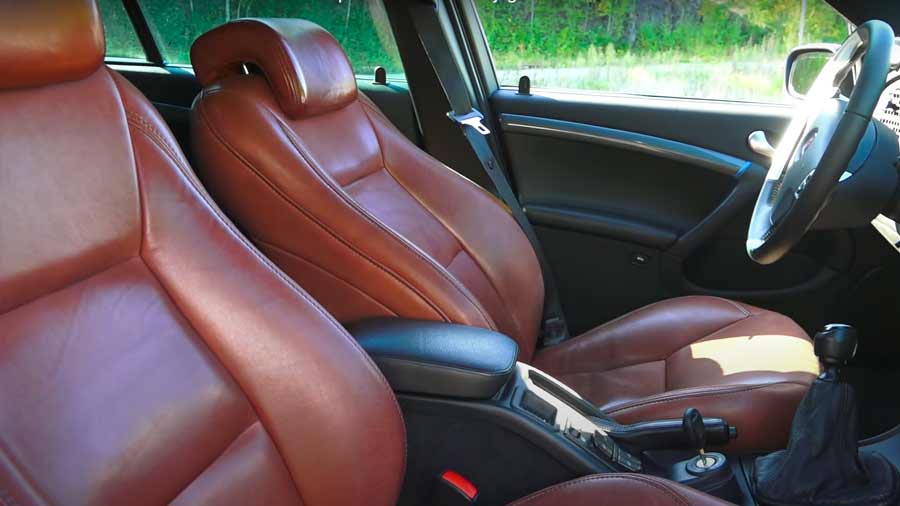 The custom oxblood leather interior, inspired by the classic Saab 900, elevates the cabin of this 2006 Saab 9-5 Sportwagon, blending vintage luxury with modern refinement.