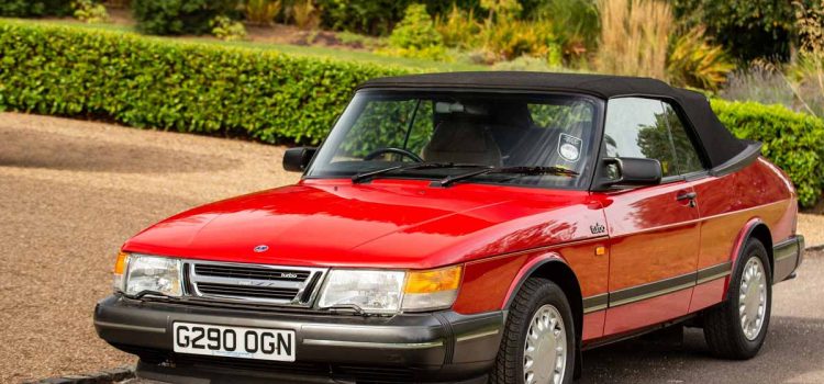 Pristine 1990 Saab 900 Turbo 16 Convertible in radiant red, a classic beauty that recently fetched £33,750 at auction, showcasing its impeccable preservation and low mileage.