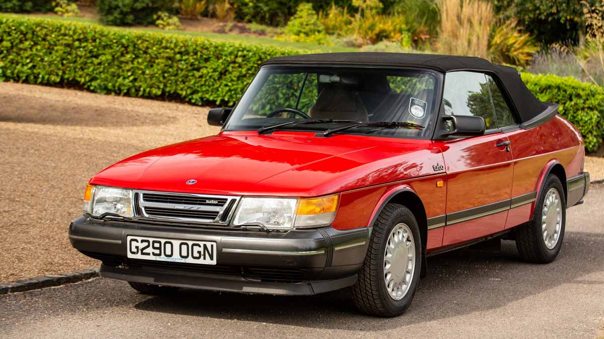 Pristine 1990 Saab 900 Turbo 16 Convertible in radiant red, a classic beauty that recently fetched £33,750 at auction, showcasing its impeccable preservation and low mileage.