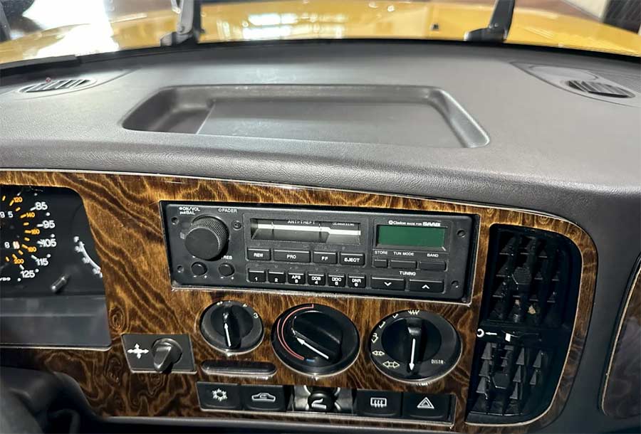 A close-up of the 2002-installed wood dash panel, featuring the factory cassette stereo and HVAC controls—standing as a testament to the 900’s well-preserved originality.