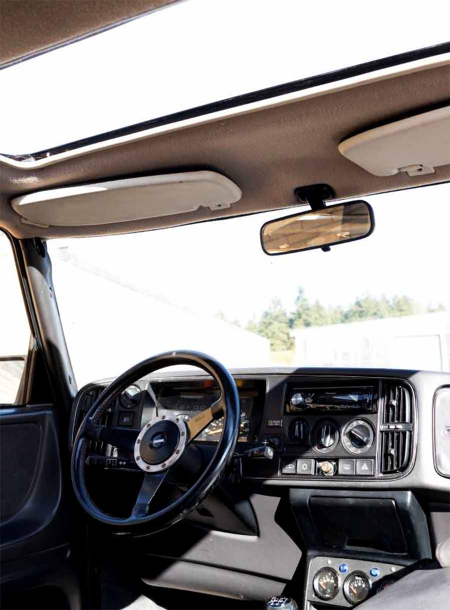 The unique and whimsical addition of an original 99 Saab Turbo steering wheel adds a touch of personality and charm to the Saab 900 Turbo SPG's interior.