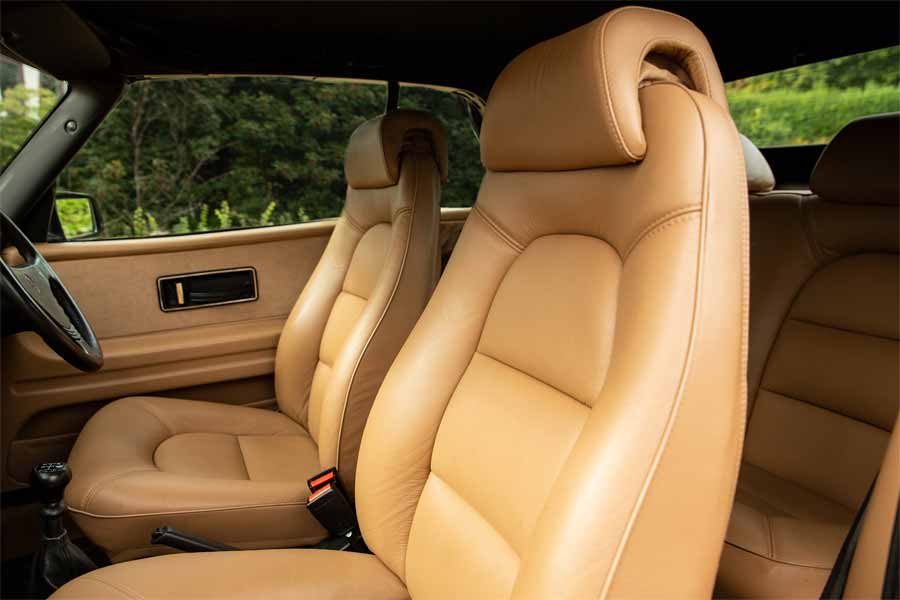 Luxurious beige leather interior of the 1990 Saab 900 Turbo 16 Convertible, combining classic style with comfort to complement its distinguished exterior.