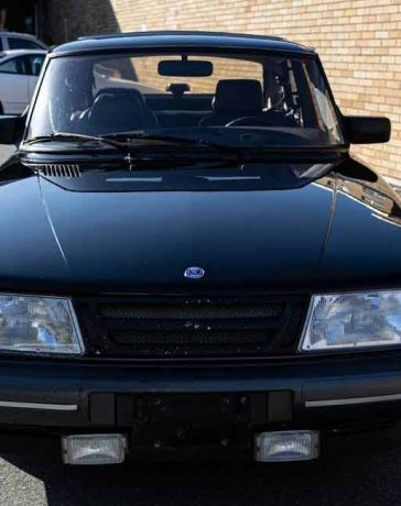 The shiny black exterior of the Saab 900 Turbo SPG with gray side moldings exudes an aggressive and visually appealing aura.