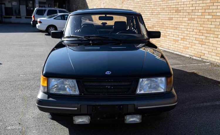 The shiny black exterior of the Saab 900 Turbo SPG with gray side moldings exudes an aggressive and visually appealing aura.