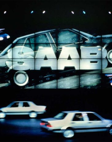 A dazzling Saab 9000 CD 1987 promotion, with two vehicles poised before a towering 26-foot-tall projection screen.