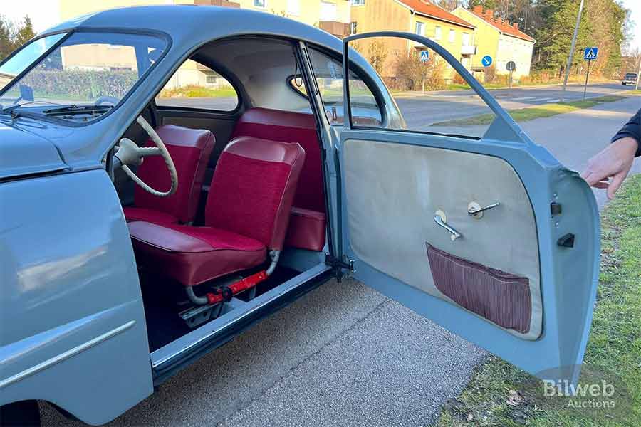 The inviting interior of the 1955 Saab 92B De Luxe, showcasing restored seats in classic red upholstery—bringing the charm of Saab's mid-century design to life.