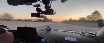 The Saab 9-5 Aero cockpit during the Cannonball Run, equipped with cutting-edge tech and pushing speeds of 140 mph at sunrise.