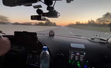 The Saab 9-5 Aero cockpit during the Cannonball Run, equipped with cutting-edge tech and pushing speeds of 140 mph at sunrise.