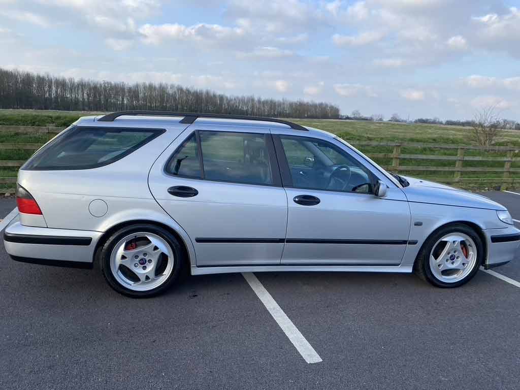 A side view of the gleaming Saab 9-5 SportCombi, showcasing its elegant lines and newly powder-coated Klingon alloys, a testament to automotive excellence and meticulous care.