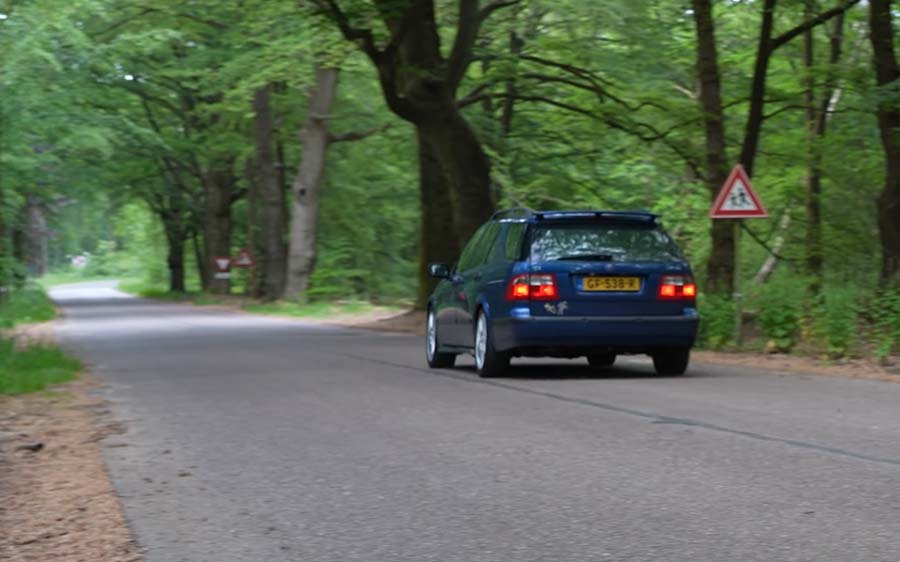 A 2002 Saab 9-5 2.2 TiD Wagon cruises along a serene, tree-lined road, embodying the spirit of resilience and timeless design as it continues its journey with nearly 600,000 kilometers on the odometer.