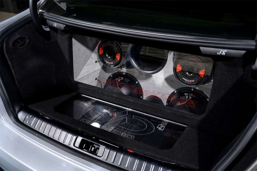 Rear trunk view showcasing the high-end audio system installed in the 2008 Saab 9-3 Aero SportSedan, featuring powerful amplifiers and premium speakers, designed to deliver an exceptional sound experience.