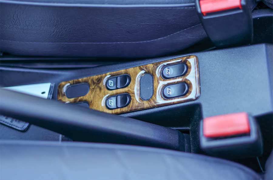 A closer look at the wood-trimmed power window switches, an accessory added by the second owner in 2002, reflecting the 900’s carefully curated interior.