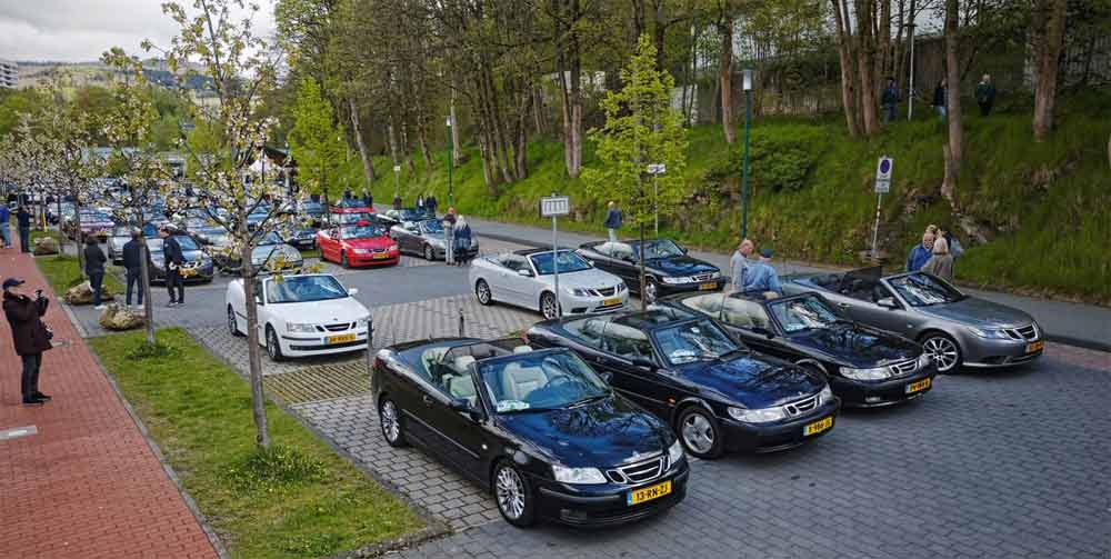 Saab convertible enthusiasts gather along a scenic urban route, adding a colorful array of well-maintained vehicles to the landscape during the 2024 Saab Convertible Weekend, reflecting the vibrant spirit and dedication of the Saab Cabrio-groep Nederland. (photo by David Joost Kamermans)