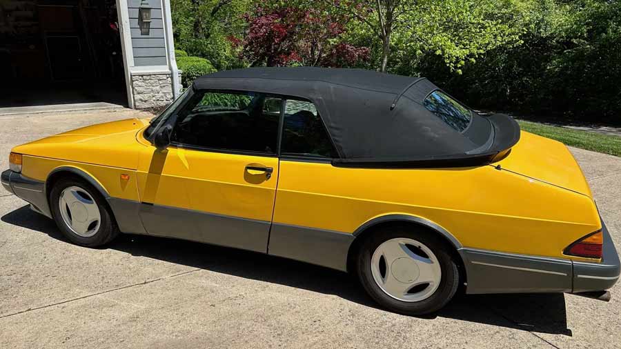  Despite its vibrant Monte Carlo Yellow exterior, this 1991 Saab 900 SE Turbo Convertible shows some surface corrosion underneath, a testament to its storied history.