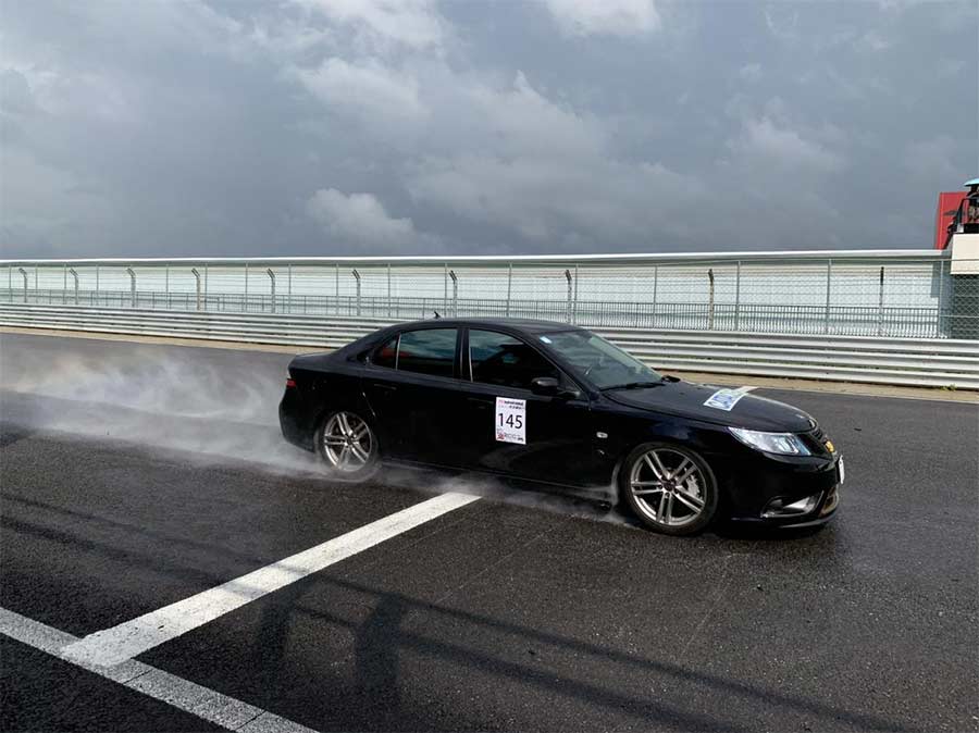 A sleek Saab 9-3 Turbo X, equipped with Hirsch Performance upgrades, demonstrating its power and agility on a wet track during a racing event in Taiwan. 