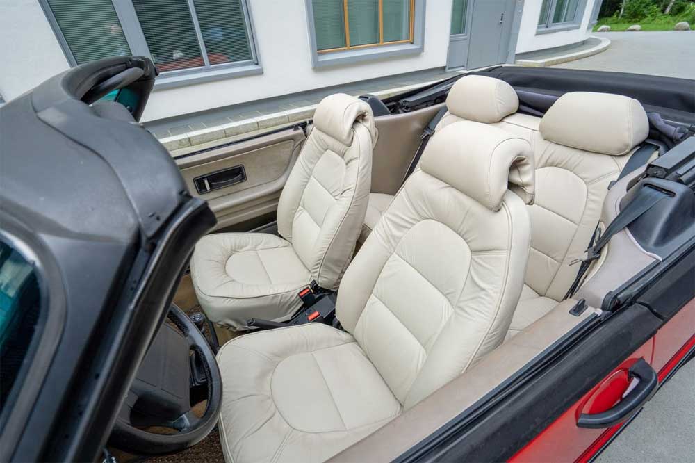 Saab 900 Turbo Convertible with a freshly reupholstered sand-colored leather interior, marrying comfort with classic style.